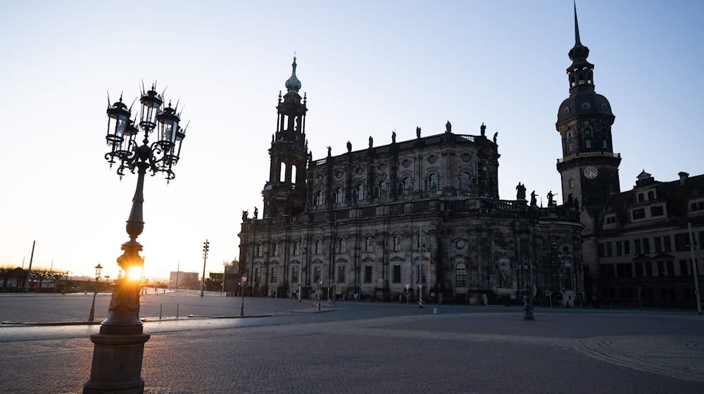 Der Theaterplatz mit der Katholischen Hofkirche (l) und dem Hausmannsturm bei Sonnenaufgang. / Foto: Sebastian Kahnert/dpa