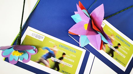 Two certificate folders and colorful paper flowers for the first graduates of Dresden University School