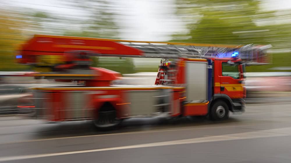 Ein Feuerwehrfahrzeug mit Drehleiter fährt in der Innenstadt zu einem Einsatz. / Foto: Robert Michael/dpa-Zentralbild/dpa