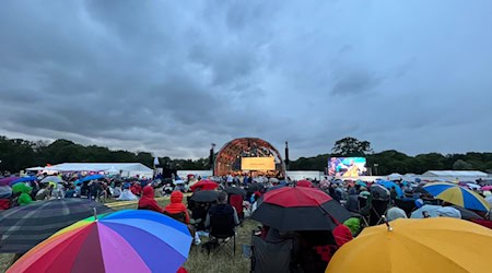 Tausende Besucher sitzen mit Regenschirmen im Rosenthal und hören einem Open-Air Konzert des Leipziger Gewandhausorchesters zu. / Foto: Jan Woitas/dpa