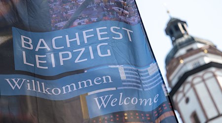 علم مهرجان باخ في مدينة لايبزيغ يرفرف في يوم الافتتاح بجانب برج كنيسة القديس توماس. / الصورة: هندريك شميت/وكالة الأنباء الألمانية