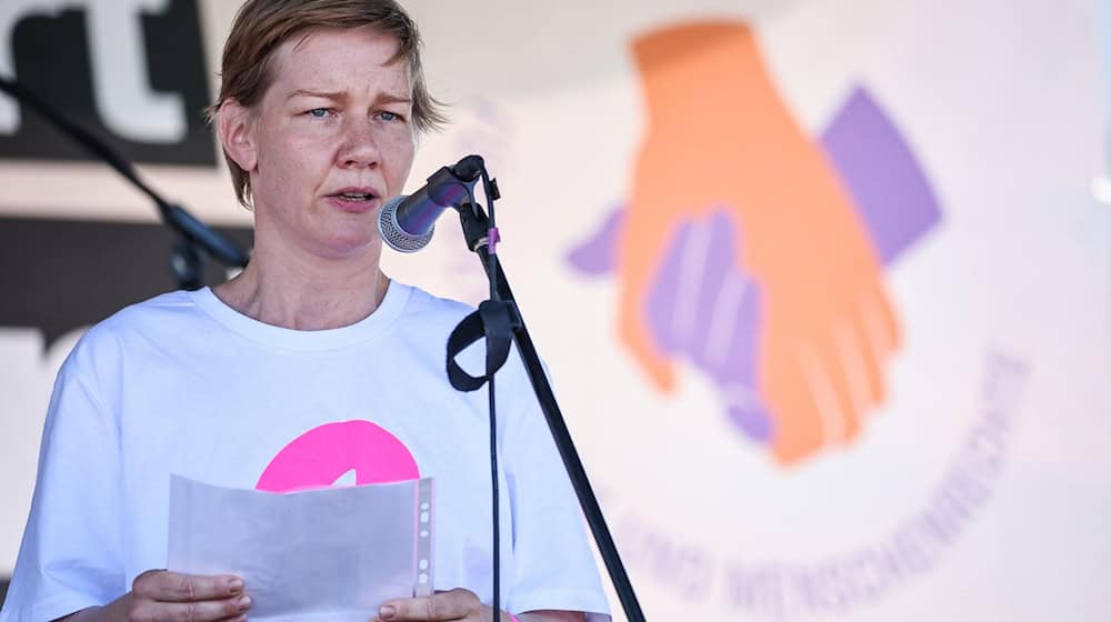 Die deutsche Schauspielerin Sandra Hüller spricht bei der Kundgebung «Hand in Hand für Demokratie und Menschenrechte» gegen Rechtsextremismus auf dem Leuschnerplatz. / Foto: Jan Woitas/dpa