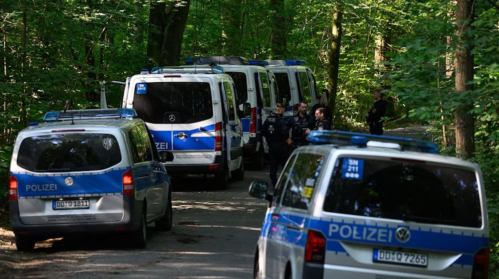 Polizisten stehen auf einer Straße in einem Wald. Bei der Suche nach der vermissten neunjährigen Valeriia hat die Polizei im sächsischen Döbeln eine Leiche gefunden. / Foto: Robert Michael/dpa