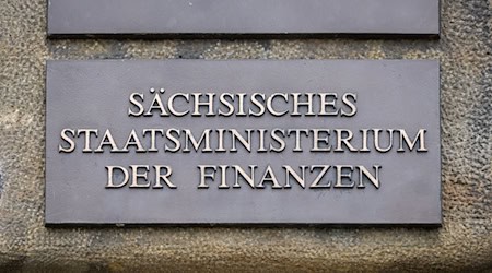 На вході до будівлі висить табличка з написом "Міністерство фінансів землі Саксонія" / Фото: Robert Michael/dpa