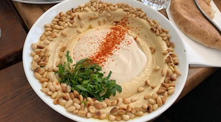 Schale mit Hummus, gerösteten Erdnüssen, Kräutern und Gewürzen