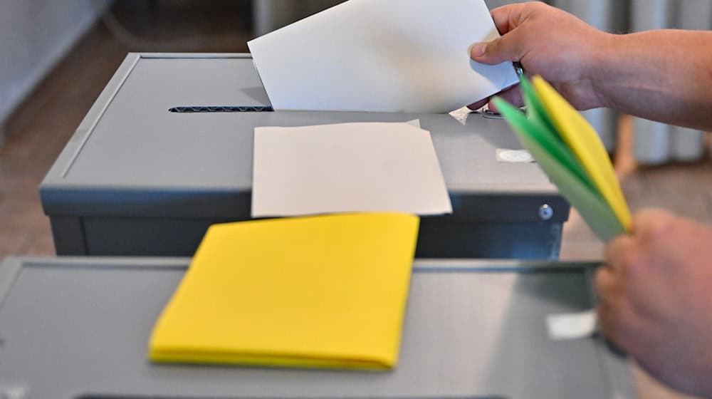 Людина опускає свій бюлетень для голосування на виборах до Європарламенту в урну для голосування / Фото: Patrick Pleul/dpa