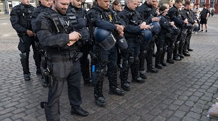 Kurz nach dem Bekanntwerden seines Todes trauern Polizisten in Mannheim um ihren getöteten Kollegen. / Foto: Boris Roessler/dpa