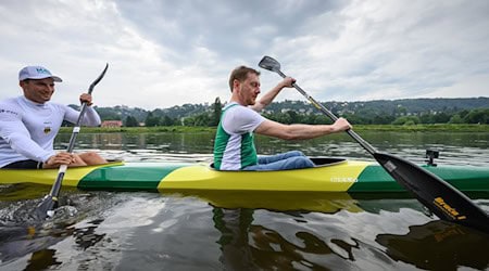 Michael Kretschmer (CDU, r), Minister President of Saxony, and Tom Liebscher-Lucz, double Olympic champion in canoeing, sit in a two-man kayak and paddle on the Elbe / Photo: Robert Michael/dpa