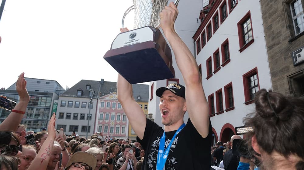 Jonas Richter, capitán del equipo de baloncesto Niners Chemnitz, celebra con el trofeo / Foto: Sebastian Willnow/dpa