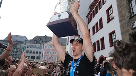 Jonas Richter, capitán del equipo de baloncesto Niners Chemnitz, celebra con el trofeo / Foto: Sebastian Willnow/dpa