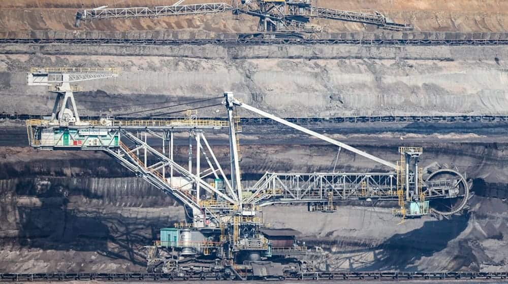 Ein Schaufelradbagger (vorn) und ein Absetzer stehen im Kohleflöz im Tagebau Vereinigtes Schleenhain. / Foto: Jan Woitas/dpa