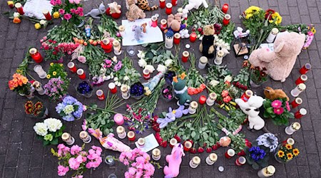 Blumen, Kerzen und Teddybären sind in der Nähe der Wohnung des getöteten Mädchens auf dem Fußweg abgelegt. / Foto: Robert Michael/dpa