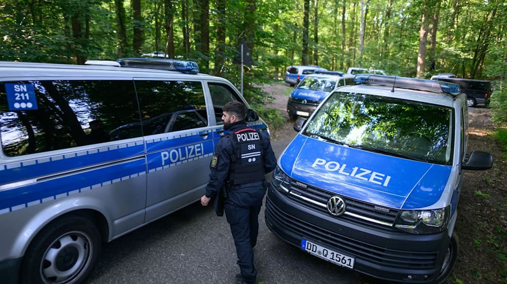 Polzisten stehen auf einer Straße in einem Wald. Bei der Suche nach der vermissten neunjährigen Valeriia hat die Polizei im sächsischen Döbeln eine Leiche gefunden. / Foto: Robert Michael/dpa