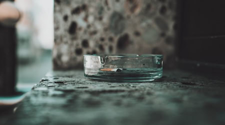 Aschenbecher mit ausgedrückter Zigarettenkippe