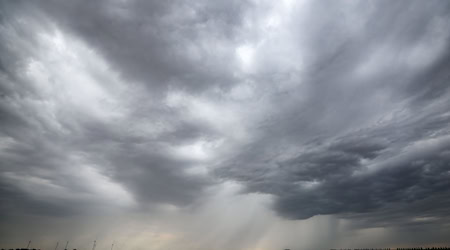 Eine Regenfront zieht über ein Getreidefeld hinweg. / Foto: Jan Woitas/dpa/Symbolbild
