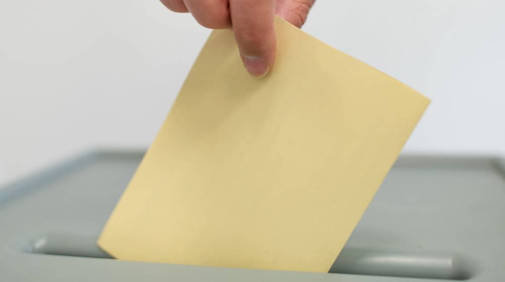 A ballot paper is thrown into a ballot box. / Photo: Uwe Anspach/dpa/Symbolic image