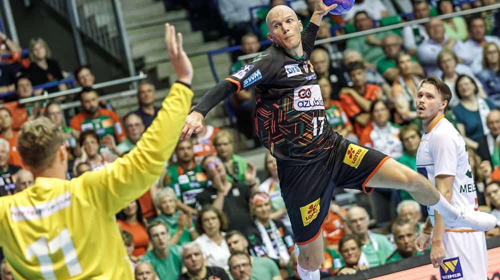 Magdeburg's Tim Hornke (r) throws the ball at the goal of HSG Wetzlar goalkeeper Till Klimpke / Photo: Andreas Gora/dpa