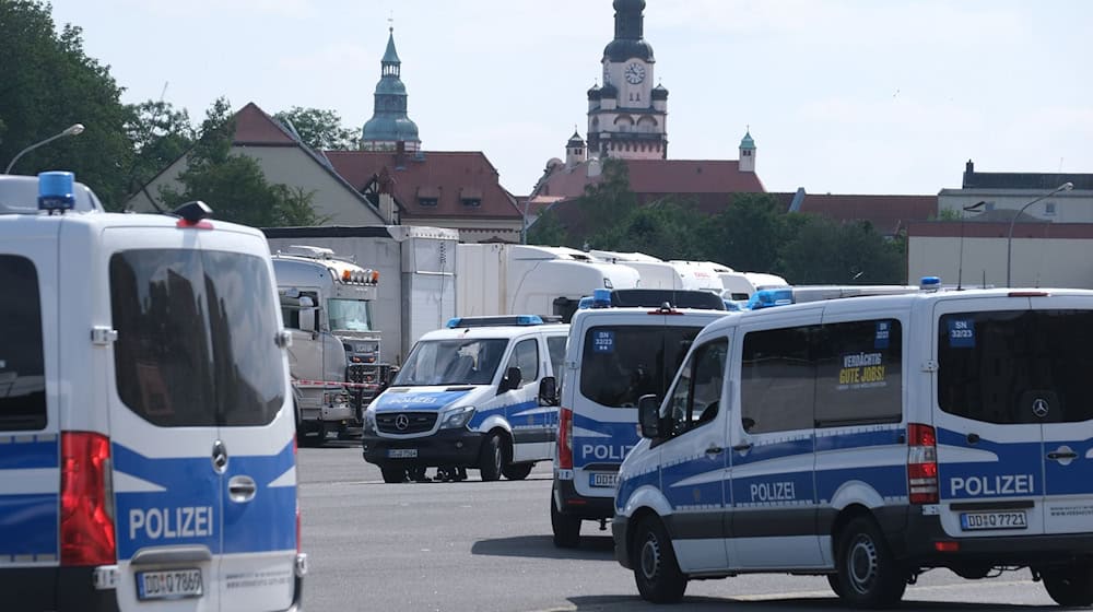 Polizisten versammeln sich auf einem Parkplatz. / Foto: Sebastian Willnow/dpa