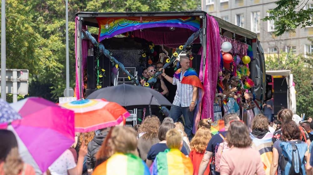 Menschen feiern bei der Parade zum Christopher Street Day in der Sächsischen Landeshauptstadt auf einem Wagen bei der Fahrt durch die Straßen. / Foto: Daniel Schäfer/dpa