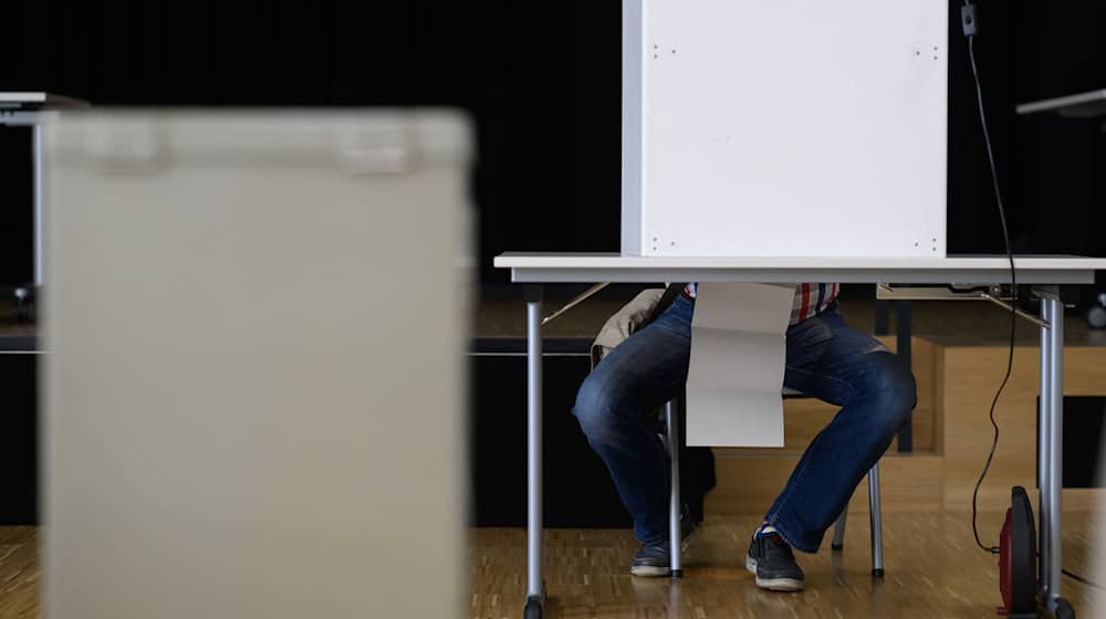 Ein Mann sitzt während der Europawahl in einer Wahlkabine, um seinen Wahlzettel auszufüllen. Die Europawahl begann am 6. Juni und in Deutschland wird am 9. Juni gewählt. / Foto: Robert Michael/dpa