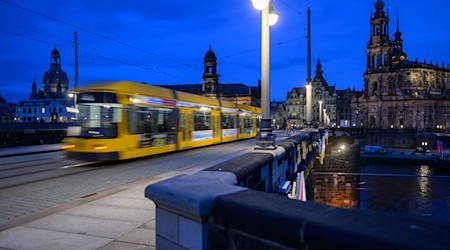 A Dresden Transport Authority (DVB) streetcar crosses the Augustus Bridge into the Old Town in the evening / Photo: Robert Michael/dpa