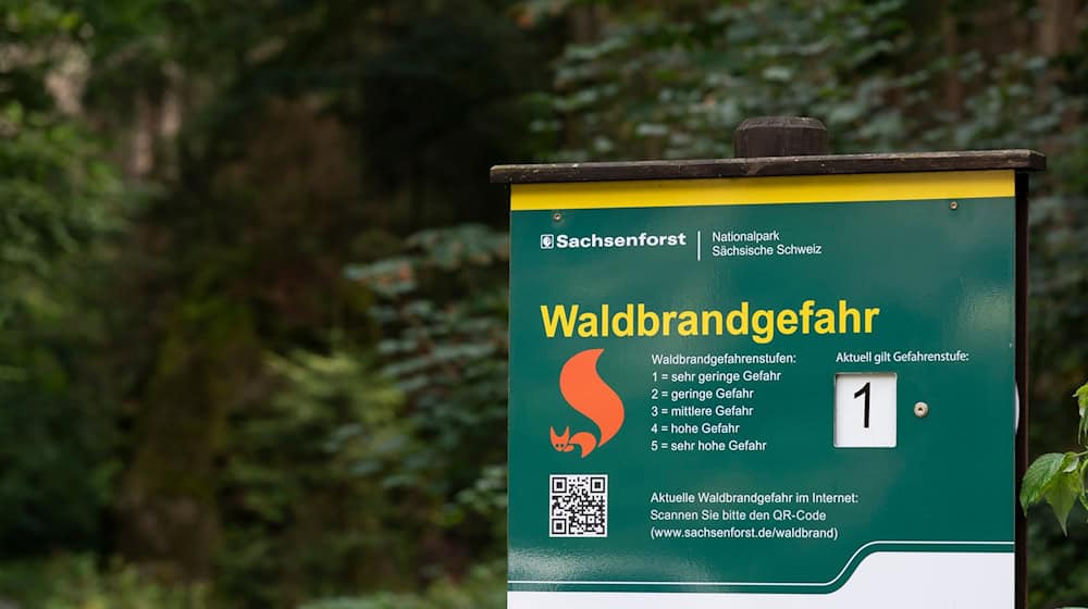 Ein Warnschild mit Informationen zum Verhalten bei Waldbrandgefahr im Nationalpark Sächsische Schweiz (Archivbild). / Foto: Matthias Rietschel/dpa-Zentralbild/dpa