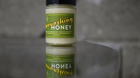 Imker Rico Heinzig hat seine Honiggläser mit einem «Beewashing»-Etikett versehen (Archivbild) / Foto: Robert Michael/dpa