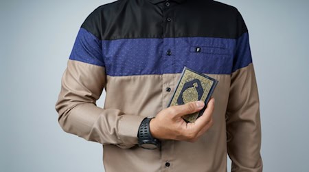 Mann in braunem Button-Up-Hemd mit Koran