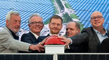 Mit einer symbolischen Inbetriebnahme ist der Energiepark Witznitz offiziell ans Netz gegangen. Auch dabei: Sachsens Ministerpräsident Michael Kretschmer (M). / Foto: Hendrik Schmidt/dpa