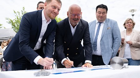 Michael Kretschmer (l.), Minister President of Saxony, and Michael Albrecht, Medical Director of Dresden University Hospital, signing documents at the laying of the foundation stone for a new building for the German Cancer Research Center (DKFZ). / Photo: Sebastian Kahnert/dpa