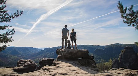 Two people with a dog standing on a rock in Saxon Switzerland / Photo: Vanessa Bieling/TMGS/Vanessa Bieling/TMGS/dpa