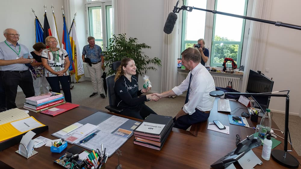 W Sakskej statnej kencliji bě tež ministerski prezident Michael Kretschmer tu, Denise Dönitz z Döbelna přepoda jemu dar. / Foto: Daniel Wagner/dpa