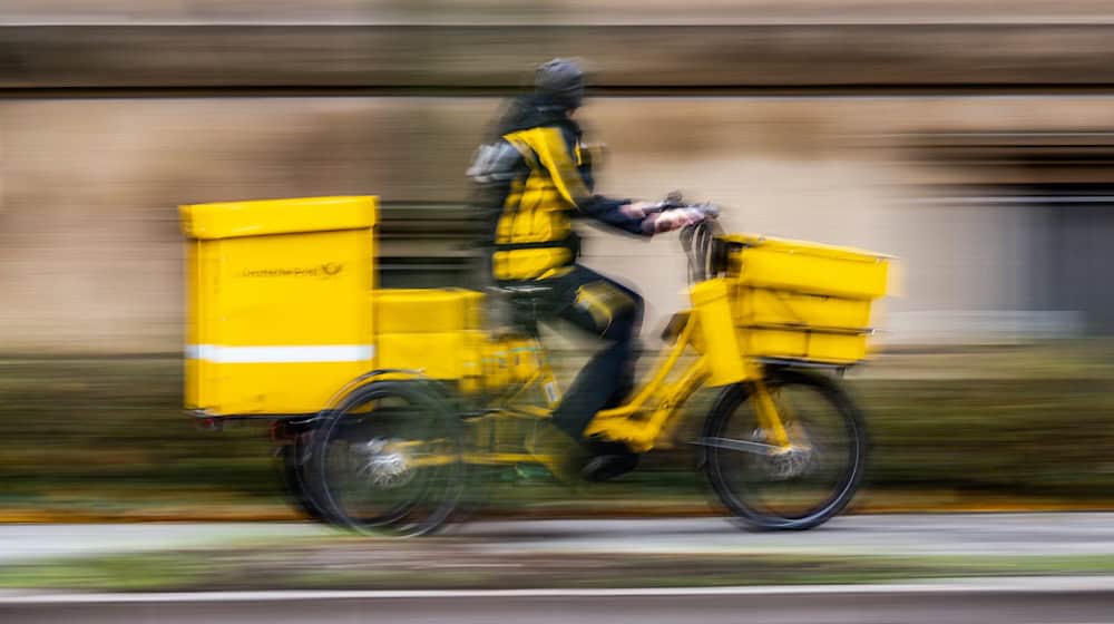 Ein Postbote ist in Dresden unterwegs (Symbolbild). / Foto: Robert Michael/dpa