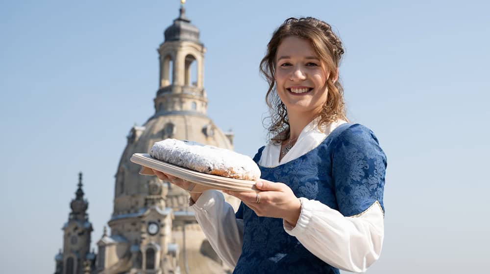 La 30ª Stollen Girl de Dresde, Lorna Prenzel, con uno de los famosos Striezel delante de la Frauenkirche / Foto: Sebastian Kahnert/dpa