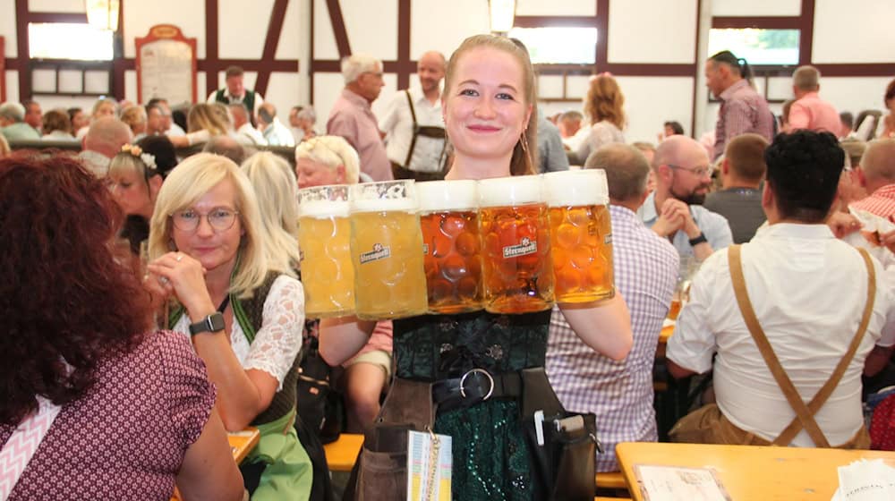 Nachschub für Bierhungrige: Katharina Höhn serviert mehrere Maßkrüge bei der «Sternquell-Wiesn» in Plauen. / Foto: Katrin Mädler/dpa-Zentralbild/dpa