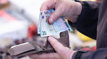 Eine Frau sortiert Geld in ein Portemonnaie (Symbolbild). / Foto: Sebastian Kahnert/dpa