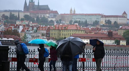 Люди гуляють під дощем вздовж річки Влтава у Празі / Фото: Дана Кеснерова/XinHua/dpa