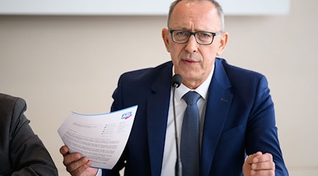 Jörg Urban, předsyda AfD w Sakskej, dźerži na nowinarskej konferency swój zjawny list frakciji BSW w ruce. / Foto: Robert Michael/dpa