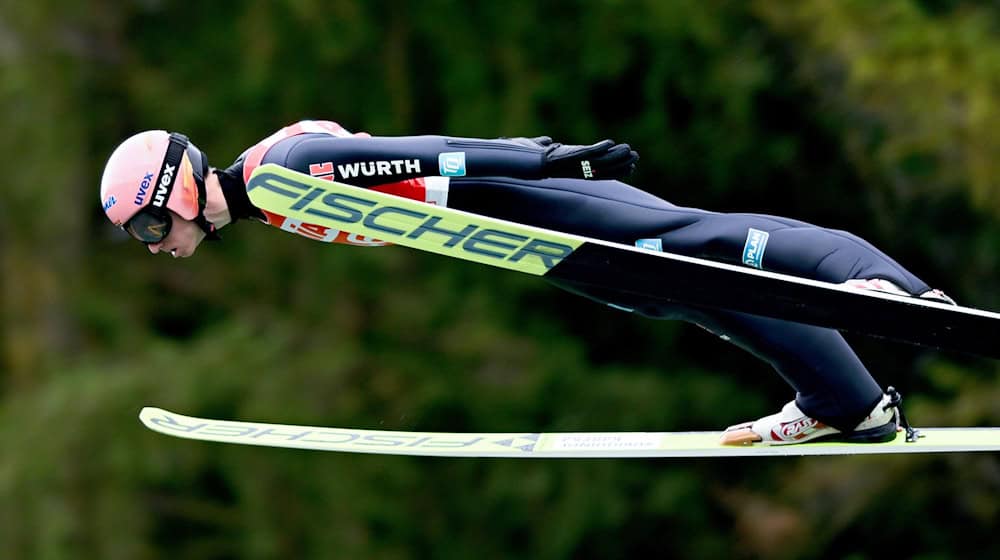 Un saltador de esquí en el Gran Premio de Verano de la FIS en vuelo desde el salto de esquí en Klingenthal frente a un bosque verde (foto de archivo) / Foto: Hendrik Schmidt/dpa