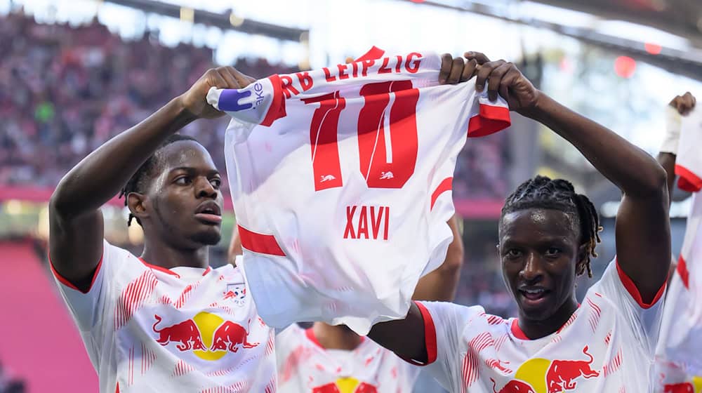 Leipzig's Castello Lukeba (l) and Amadou Haidara hold up a jersey of the injured Xavi Simons after the 2:1. / Photo: Hendrik Schmidt/dpa