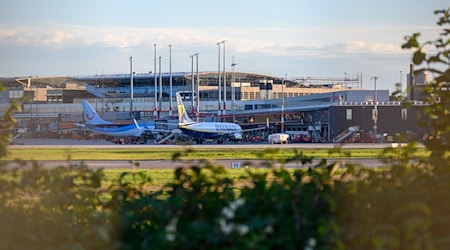 Zwei Flugzeuge stehen vor einem Terminal des Hamburger Flughafens. / Foto: Jonas Walzberg/dpa