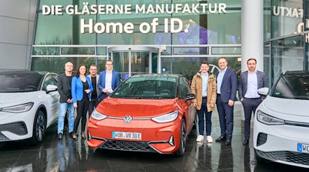 50.000 E-Probefahrer Christian Lehmann mit ID.3 GTX und einen Team vor der Gläsernen Manufaktur