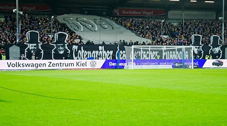 Na baneru do hry Kiel-Lipsk buchu Dietmar Hopp, Martin Kind, Oliver Mintzlaff a Jürgen Klopp jako «Tótka němskeje kopańcy» pomjenowane. / Foto: Frank Molter/dpa