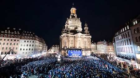 Tausende Menschen versammeln sich bei der weihnachtlichen Vesper vor der Frauenkirche Dresden.  / Foto: Sebastian Kahnert/dpa