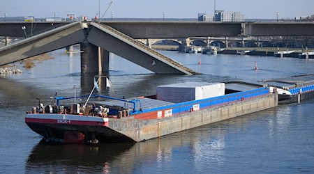 Un carguero es el primer barco que pasa bajo el puente Carola, parcialmente derrumbado / Foto: Robert Michael/dpa