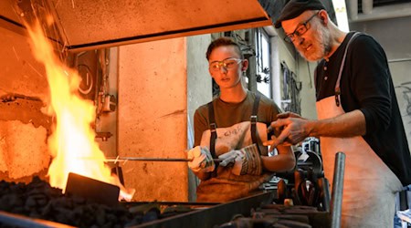 Jugendlicher und Firmenmitarbeiter arbeiten mit Feuer