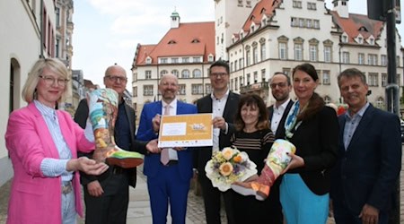 Scheckübergabe "Ab in die Mitte!" in Döbeln (© Bildrechte: Stadt Döbeln).von links nach rechts: Dr. Cindy Krause (IHK Chemnitz, Geschäftsführerin Regionalkammer Mittelsachsen), MdL Henning Homann, Staatssekretär Thomas Kralinski, Sven Liebhauser (Oberbürgermeister Döbeln), Künstlerin Olga Scheck, Jan Hasek (EDEKA), Simone Epperlein (SachsenLotto), Dr. Eddy Donat (Projektleitung "Ab in die Mitte")