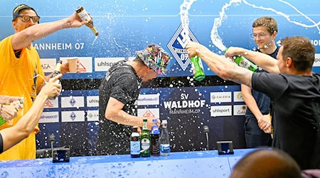 Dresdens Spielern feiern mit einer Bierdusche ihres Trainers Thomas Stamm (M) den Aufstieg in die 2. Fußball-Bundesliga. / Foto: Uwe Anspach/dpa