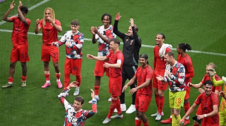 Thomas Müller (delante) se unió a la ola con los aficionados tras el empate a 3-3 en Leipzig / Foto: Hendrik Schmidt/dpa
