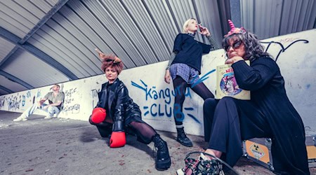 Vier Darsteller:innen in einem urbanen Setting mit Graffiti, darunter Katja Reimann mit Känguruohren und Boxhandschuhen – Szene aus der Inszenierung Die Känguru-Chroniken des Deutsch-Sorbischen Volkstheaters Bautzen.